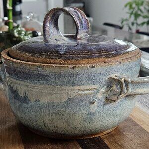 Handmade pottery covered casserole dish with lid and handles signed by artisan.